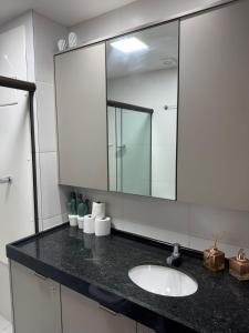 a bathroom with a sink and a mirror at Makia Beach experience 107 D Premium in Ipojuca