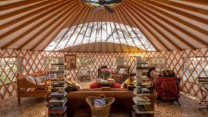 a yurt with a couch and chairs and a large window at Cozy Romantic Yurt Rental in Woodlands near California Beach Town of Cayucos in Cayucos