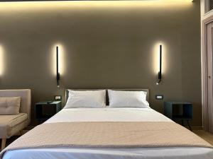 a bedroom with a large bed with two tables and two lamps at al Vico Bedrooms in Crotone