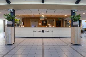 um átrio do hotel com um balcão de recepção com vasos de plantas em Fletcher Hotel - Resort Spaarnwoude em Velsen-Zuid mais 45 fotografias