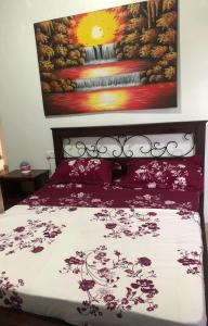 a bedroom with a bed with a painting on the wall at Neema maison de Glamour in Entebbe