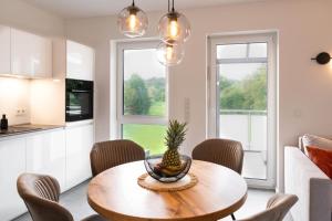 a kitchen and dining room with a table with a pineapple on it at Premiumzeit Pure Apartment Bostalsee mit Infrarotkabine in Nohfelden