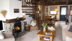 ein Wohnzimmer mit Kamin und Treppe in der Unterkunft Craobh Haven Cottages in Craobh Haven
