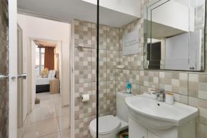 Un baño con inodoro, lavabo y espejo. en Seaside Sunsets, en Strand 35 fotos más