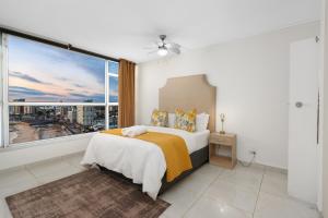 Un dormitorio con una cama y una ventana grande en Seaside Sunsets, en Strand