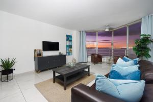 Una sala de estar con un sofá y un televisor. en Seaside Sunsets, en Strand