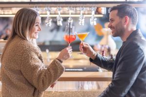a man and a woman holding glasses of wine at Hotel Pirchnerhof in Reith im Alpbachtal