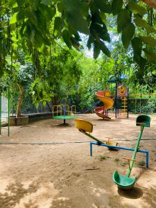 a playground with different colored play equipment in a park at Ponni Delta Nature Stay by the River in Fort +24 photos