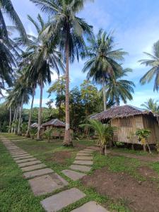 a path in front of a resort with palm trees at Tay Deling's Place in El Nido