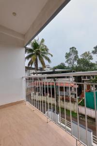 Immanuel Homestay, Kalathipady, Kottayam, Flat E في كوتايم: بلكونة فارغة مطلة على نخلة