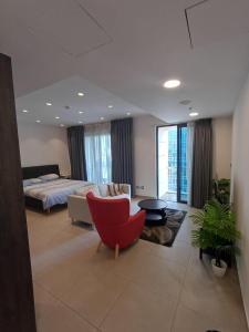 a living room with a bed and a red chair at Studio at Damak Jordan in Amman