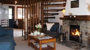 ein Wohnzimmer mit Kamin und Couch in der Unterkunft Craobh Haven Cottages in Craobh Haven
