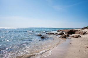 a beach with rocks and the ocean on a sunny day at 3BR Pool Villa Beach Access Patumnak Hill in Pattaya South +1 photo