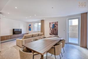 a living room with a wooden table and chairs at The Pender LUX HUB - 4BR villas with Pool, WIFI & AC by 360 Estates in St Julian's