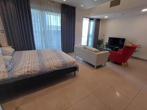 a bedroom with a bed and a couch and a television at Studio at Damak Jordan in Amman