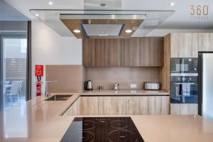 a kitchen with a sink and a stove at The Pender LUX HUB - 4BR villas with Pool, WIFI & AC by 360 Estates in St Julian's +121 photos