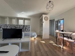 ein Wohnzimmer mit einem TV und einem Tisch mit Stühlen in der Unterkunft V3 Studio tout confort plein centre 5 min Golfech in Valence-dʼAgen + 25 Fotos