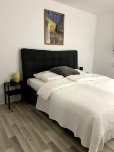 a bed with a black headboard in a bedroom at Somewhere2Stay Apartment in Oberhausen City in Oberhausen