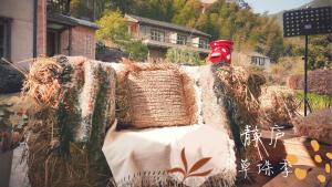 een sculptuur van een bank met hooi erop bij Jinglu Lanshan Inn in Fuchunjiang