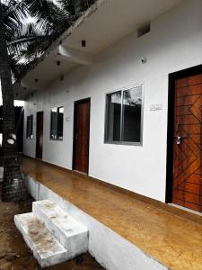 une pièce avec des murs blancs et des portes en bois dans l'établissement Secret Paradise, à Gokarna