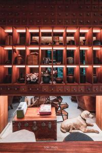 een hond die op de vloer ligt onder een houten kast bij Jinglu Lanshan Inn in Fuchunjiang +92 foto's