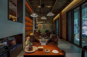 een kamer met een tafel en stoelen en een open haard bij Jinglu Lanshan Inn in Fuchunjiang