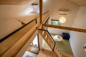 a tiny house with a bed and a staircase at Silver Daisy Stay Nikko in Nikko
