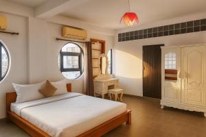 金边Downtime Hotel Phnom Penh的卧室里有一张床和一张书桌