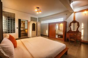 金边Downtime Hotel Phnom Penh的卧室里有一张床、一张桌子和一面镜子 更多33张照片