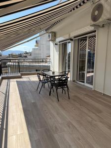 a patio with a table and chairs on a balcony at Feels Like Home - Agrinio Suites in Agrinio