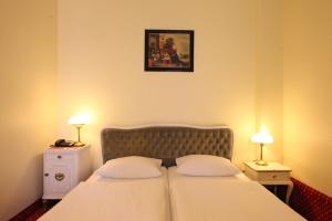 a bedroom with a bed with two pillows and two lamps at Acom Hotel Berlin Kurfürstendamm in Berlin