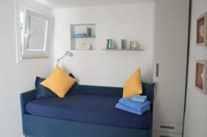 カプリにあるLa Dépendanceの青いソファ(黄色と青の枕付)