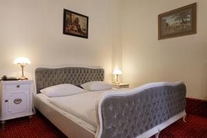 een slaapkamer met een bed met een blauw gecapitonneerd hoofdeinde bij acom Hotel Berlin Kurfürstendamm in Berlijn