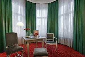 a room with green curtains and a table and chairs at Acom Hotel Berlin Kurfürstendamm in Berlin