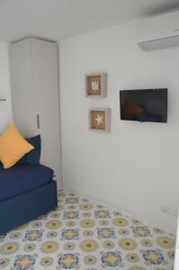 カプリにあるLa Dépendanceの青いソファとテレビのあるリビングルーム