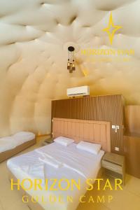 a bed in a room with a houston star golden camp sign at Horizon Star Golden Camp in Wadi Rum +45 photos