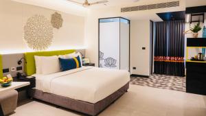 a hotel room with a large bed and a desk at ZIBE Luxe Kakinada by GRT Hotels in Kākināda