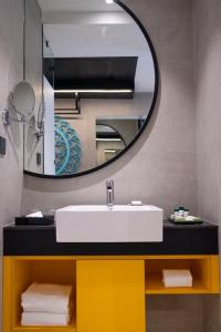 a bathroom with a sink and a mirror at ZIBE Luxe Kakinada by GRT Hotels in Kākināda