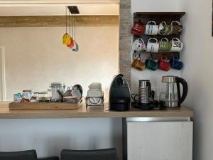 a kitchen counter with cups and utensils on a shelf at Venezia-Mestre Train Station Relax Suites in Venice