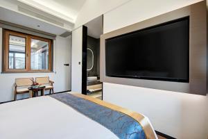 a bedroom with a large television on a wall at 泊云小筑民宿 in Datong