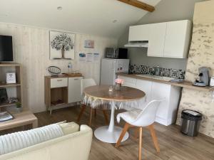 a living room with a table and a kitchen at Gîte avec vue imprenable sur la campagne in Courgains