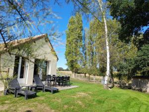 a group of chairs and tables in a yard at Gîte avec vue imprenable sur la campagne in Courgains