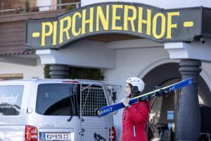 a woman holding skis in front of a store at Hotel Pirchnerhof in Reith im Alpbachtal