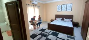 a man and a woman sitting in a bedroom at Bissau Appart Residence in Bissau +12 photos