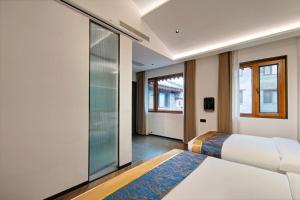 a bedroom with two beds and a glass wall at 泊云小筑民宿 in Datong +42 photos