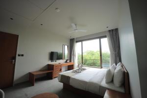 a bedroom with a bed and a large window at Club Mahindra Pavagadh in Rawālia