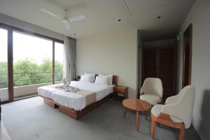 a bedroom with a bed and a large window at Club Mahindra Pavagadh in Rawālia +31 photos