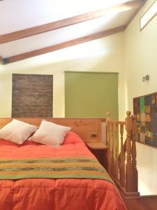 1 dormitorio con cama roja y pantalla verde en Tribu Malen Apartamentos, en Temuco