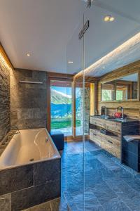ein Badezimmer mit Badewanne und Waschbecken in der Unterkunft Chalet Wooden Pearl - Ultimate Luxury & Privacy! in Saas-Fee