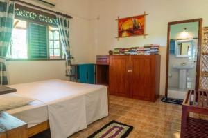a bedroom with a bed and a sink and a mirror at Magnoon in Hikkaduwa